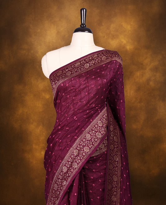 Grape wine colour Banarasi Bandhani silk saree featuring pink hand Bandhani patterns, complemented by traditional antique zari woven border and grand pallu, paired with matching antique zari brocade blouse.