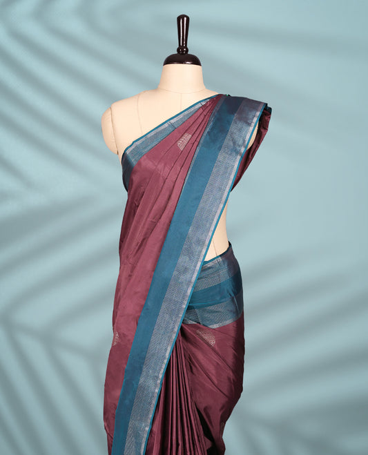 Onion coloured semi silk saree features silver zari motifs and is paired with a contrasting teal blue and silver zari border, with a matching blouse.