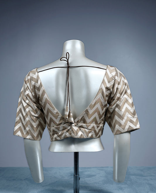Beige and cream V neck padded readymade blouse featuring a bold chevron pattern with elbow length sleeves, crafted in a glossy fabric for a stylish, contemporary ethnic look.