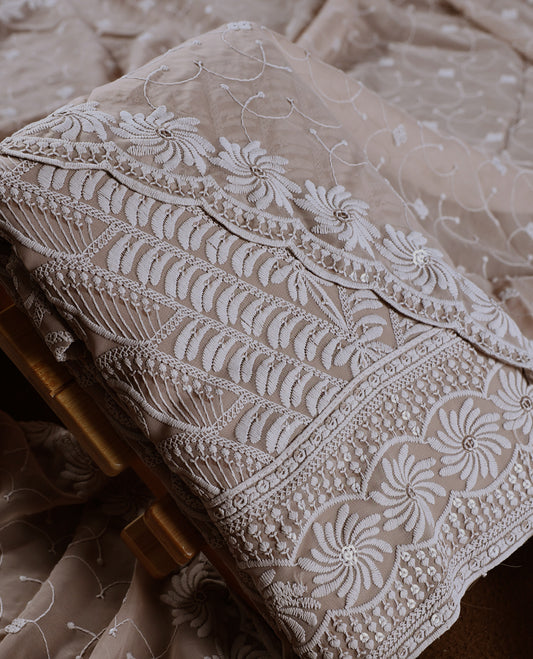 Graceful Taupe colour churidhar material adorned with intricate white floral embroidery and delicate thread patterns, paired with a plain matching bottom and embroidered dupatta, perfect for festive and elegant occasions