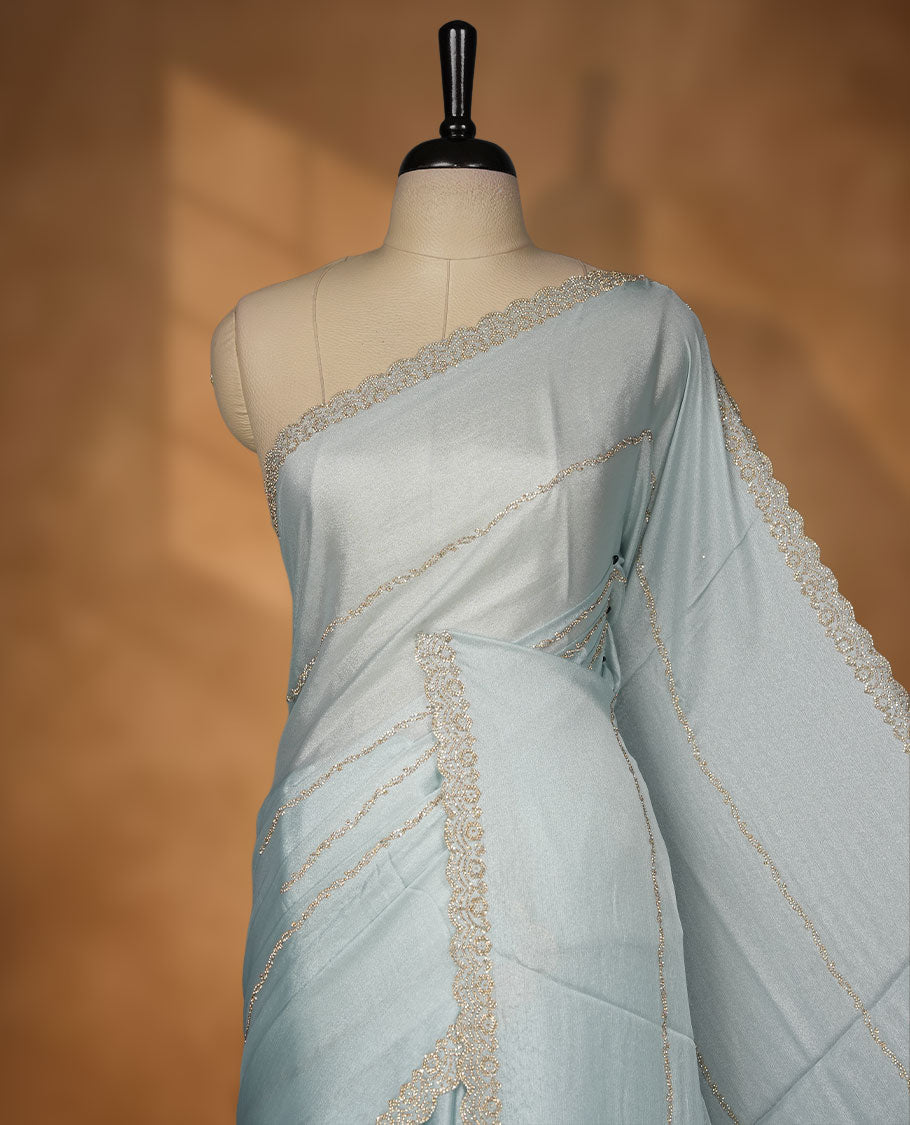 Powder Blue colour net shimmer fancy saree with a plain body, paired with a delicate stone worked border, with matching blouse