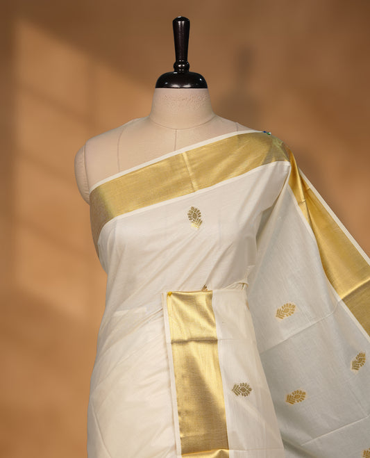 Elegant off white colour cotton Kerala saree with gold zari buttas, broad kasavu border, and richly woven traditional pallu, paired with a matching blouse