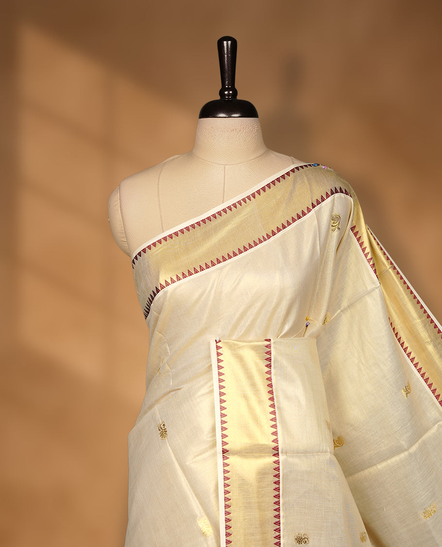 Elegant Light gold colour tissue Kerala saree with gold zari buttas, broad kasavu border with maroon temple design, and richly woven traditional pallu, paired with a matching blouse