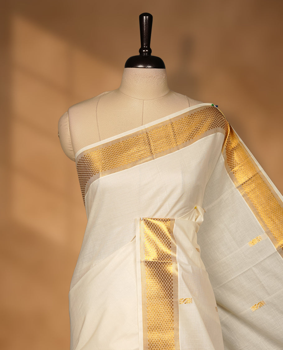 Elegant off white colour cotton Kerala saree with gold zari buttas, broad kasavu border, and richly woven traditional pallu, paired with a matching blouse