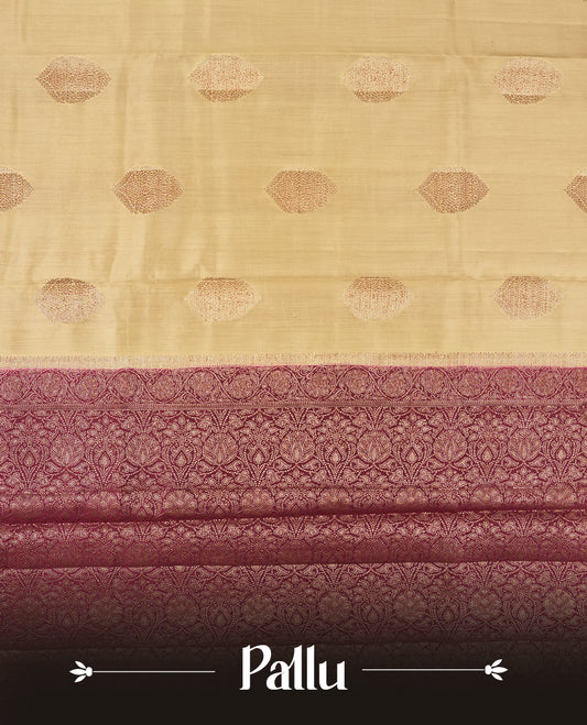 Cream Colour Banaras Soft Silk Saree with Gold Zari Oval Leaf Buttas, Intricate Multi-Layered Floral Border, Grand Pallu with Intricate Brocade Motifs in Deep Maroon and Gold Tones, and Matching Blouse.