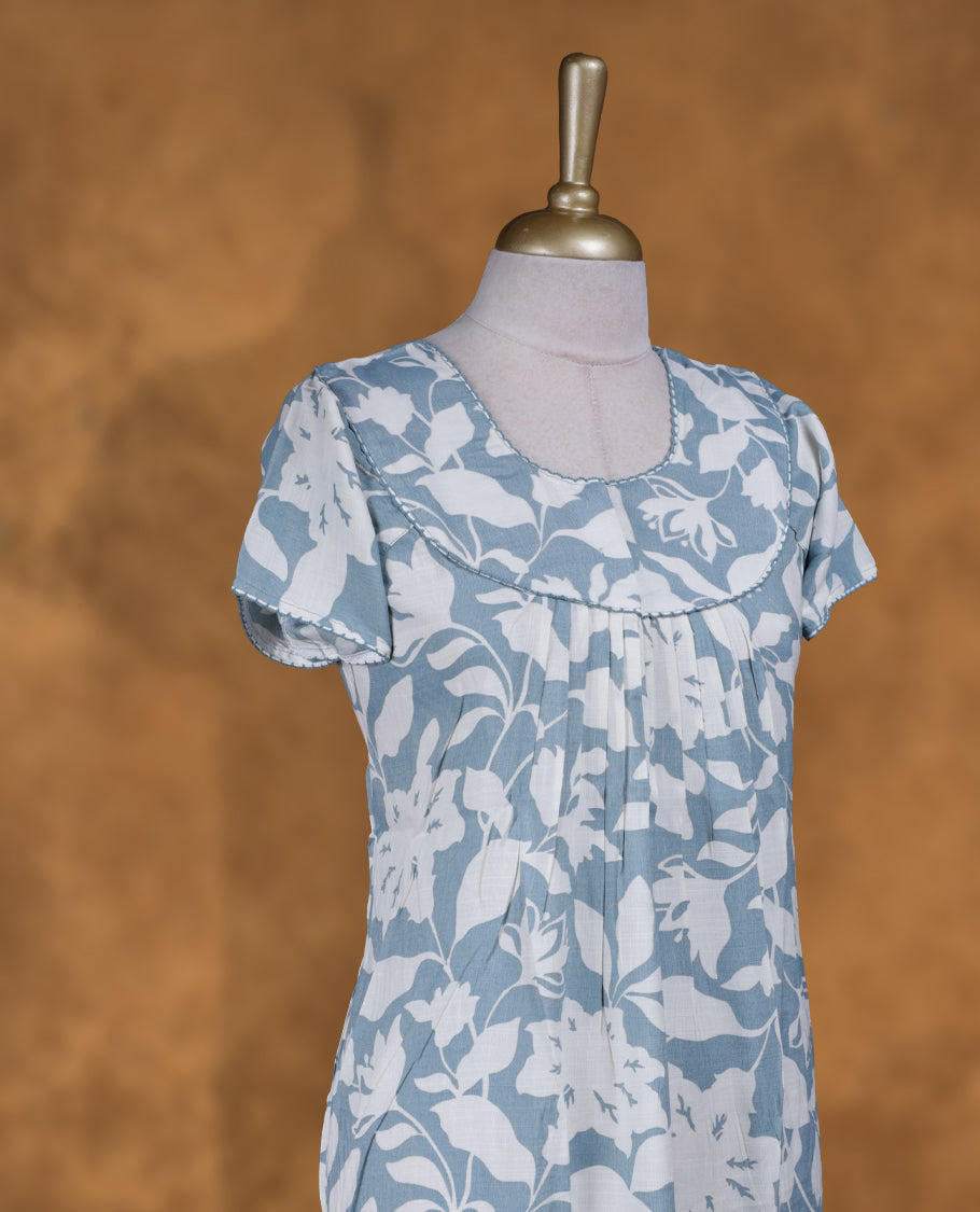 Aqua Blue colour NStyle nighty featuring white floral patterns, a round neckline with thread detailing, short sleeves, and a full ankle-length design.
