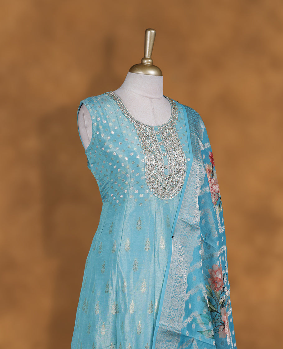 Aquamarine blue colour churidar set featuring round neckline, sleeveless pattern, and heavy sequin-embellished yoke with woven butti motifs on body, paired with a matching jacquard floral printed dupatta.