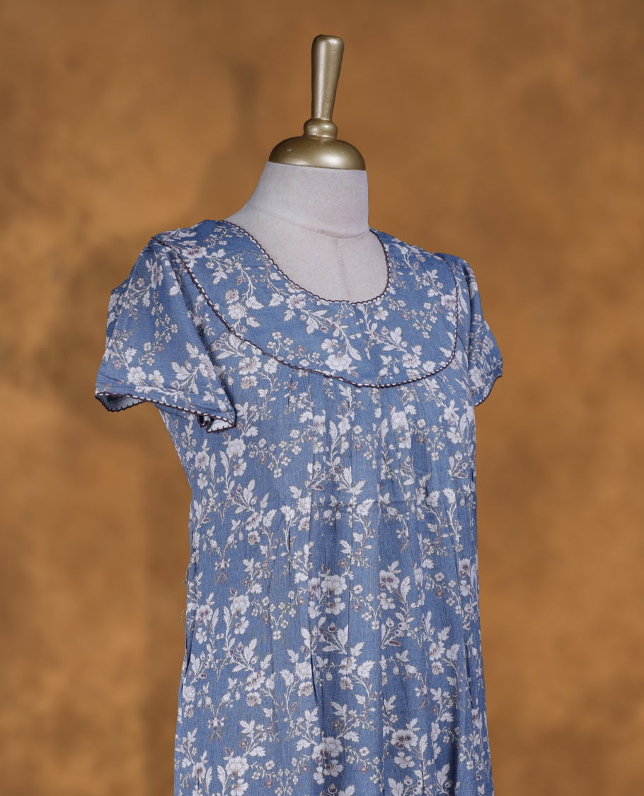 Sky blue colour NStyle nighty featuring White floral patterns, a Round neckline and thread border, short sleeves, and a full ankle-length design.