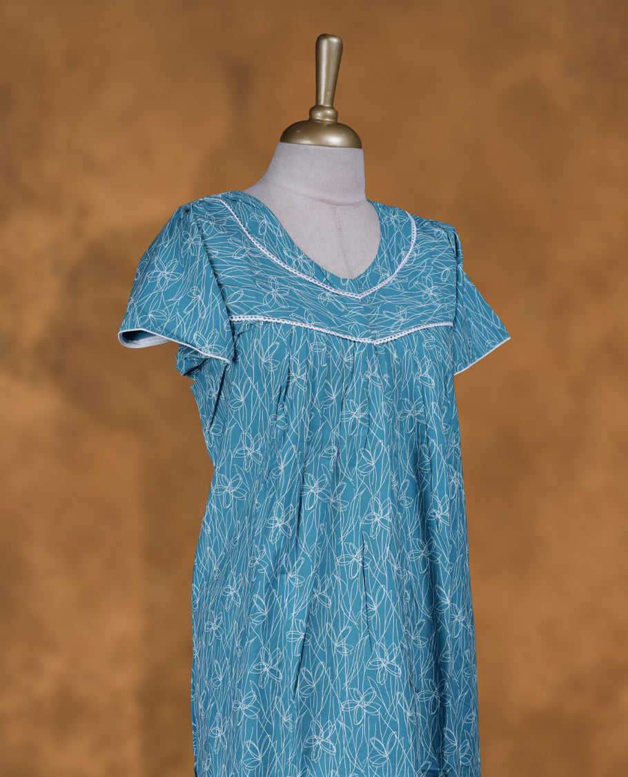 Aqua blue colour NStyle nighty featuring white patterns, a V-neckline with lace detailing, short sleeves, and a full ankle-length design.
