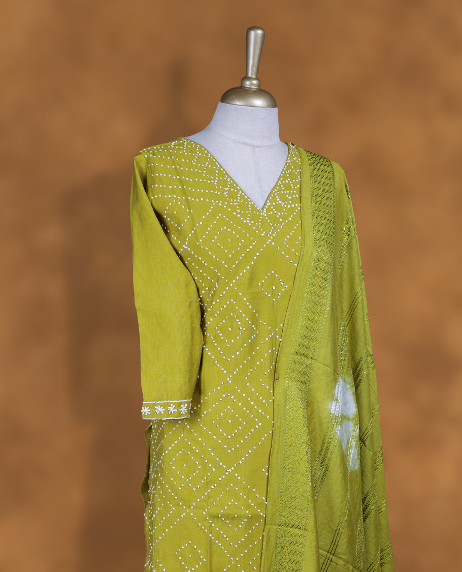 Lime green churidar set featuring V neckline, three‑fourth sleeves, and bandhani‑style dotted print on body, paired with a matching patterned dupatta.