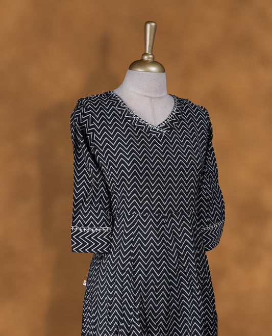 Black colour kurti by Vismay  styled with a Zigzag print pattern across on body with V neckline, knee length design, and a sleeve .