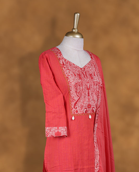 Coral pink churidar set with V neckline, three‑fourth sleeves, paisley printed yoke and matching border detailed dupatta.