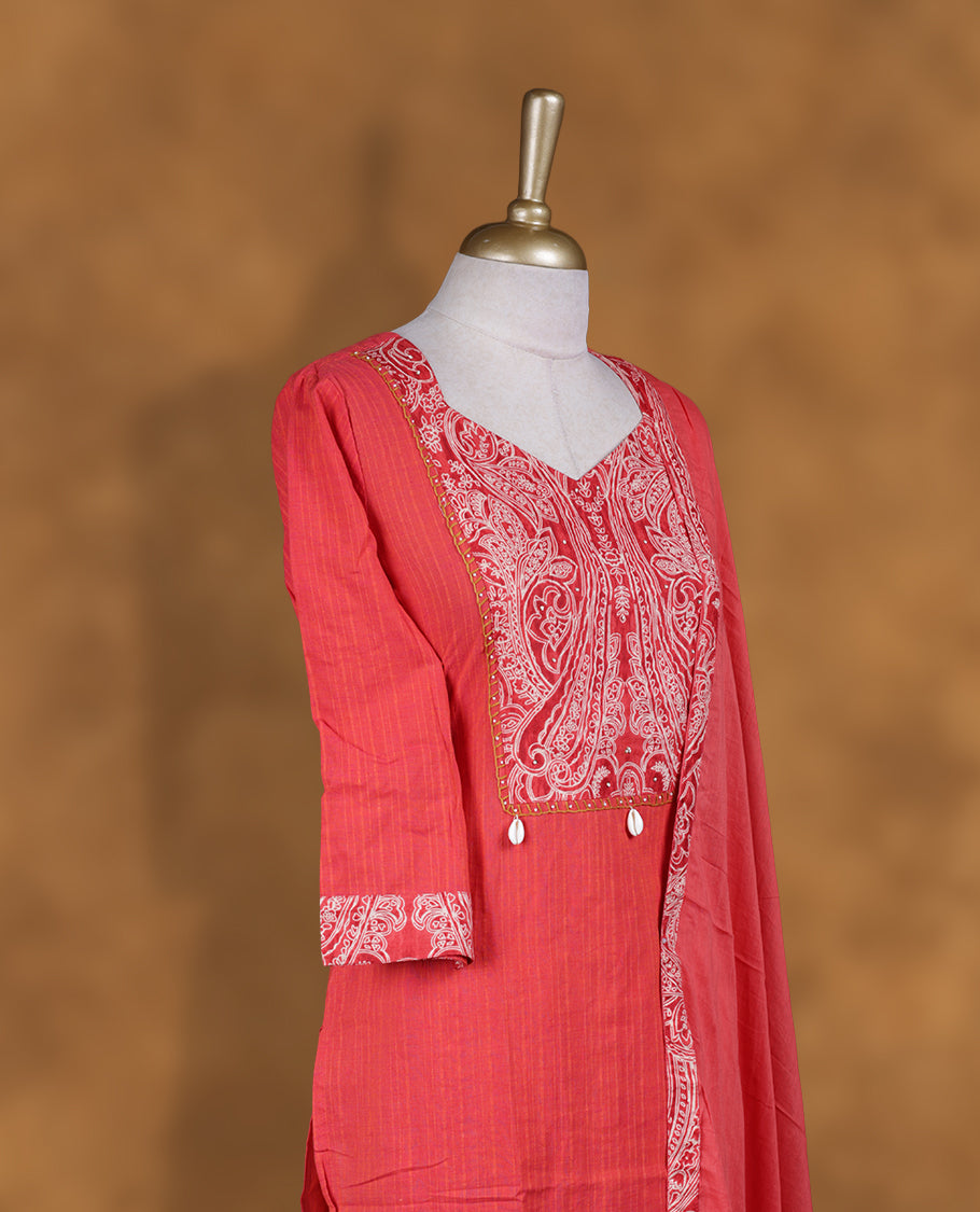 Coral pink churidar set with V neckline, three‑fourth sleeves, paisley printed yoke and matching border detailed dupatta.