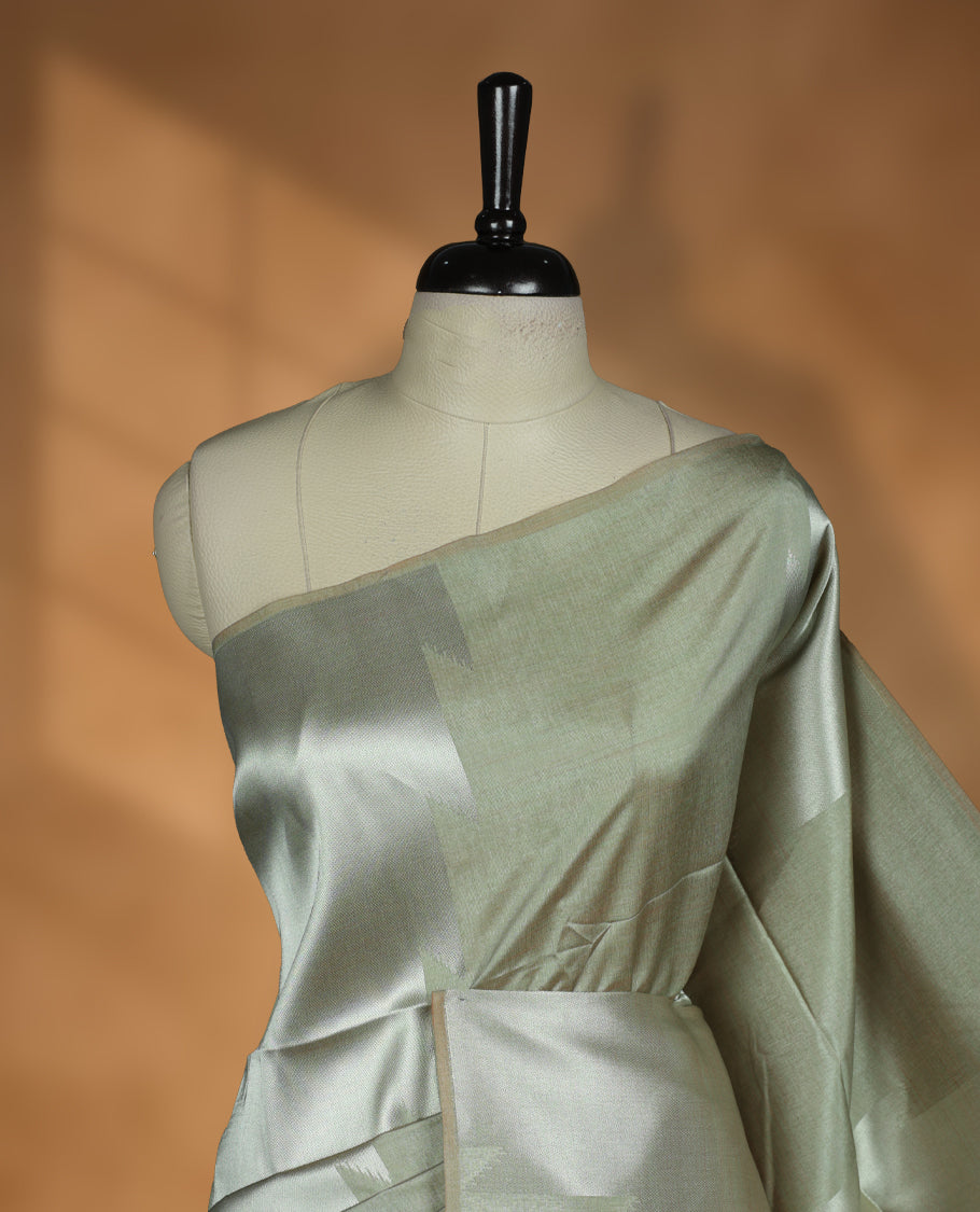 Olive and silver colour dual tone semi tussar saree featuring woven abstract geometric motifs on the body, complemented by a ikat inspired contrast Lavender purple patterned pallu, paired with a matching blouse.