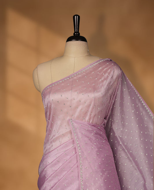 Light Purple Colour net shimmer fancy saree adorned with white stone buttas all over the body, paired with a delicate stone worked border and matching blouse