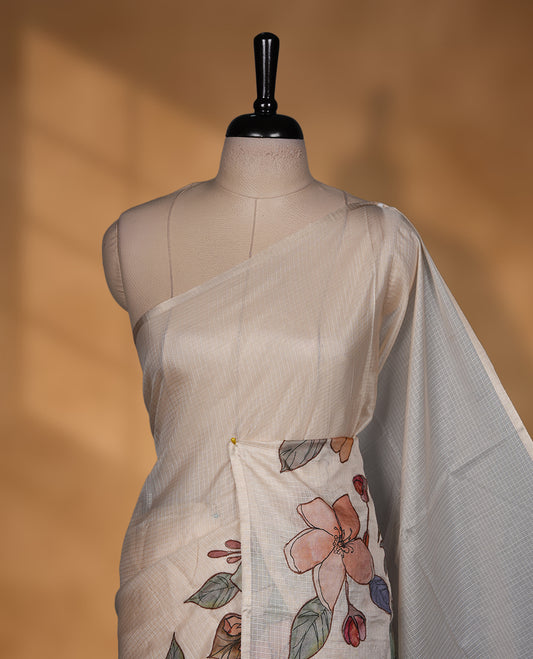 Ivory off white semi tusser silk saree featuring delicate multicolour floral prints across the pallu and lower body finished with a subtle self border and paired with a matching floral printed blouse.
