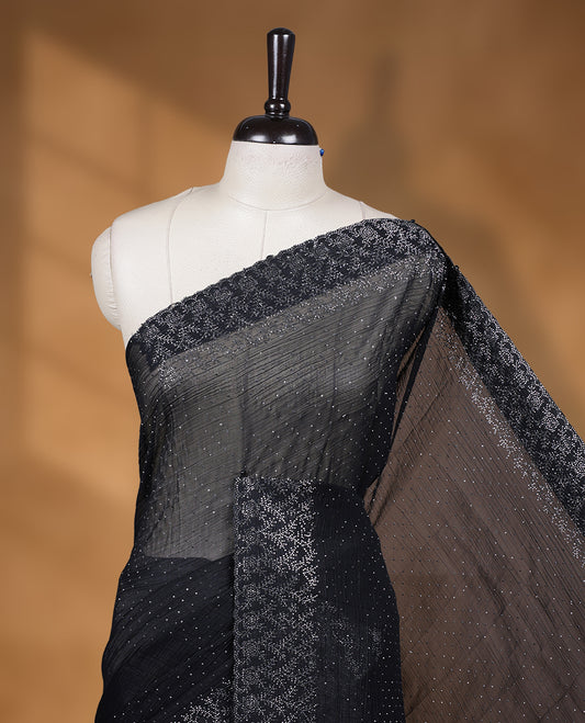 Black colour chiffon designer saree, featuring white stone all over on body, heavy stone patttern on border and  pallu, Paired with matching blouse.