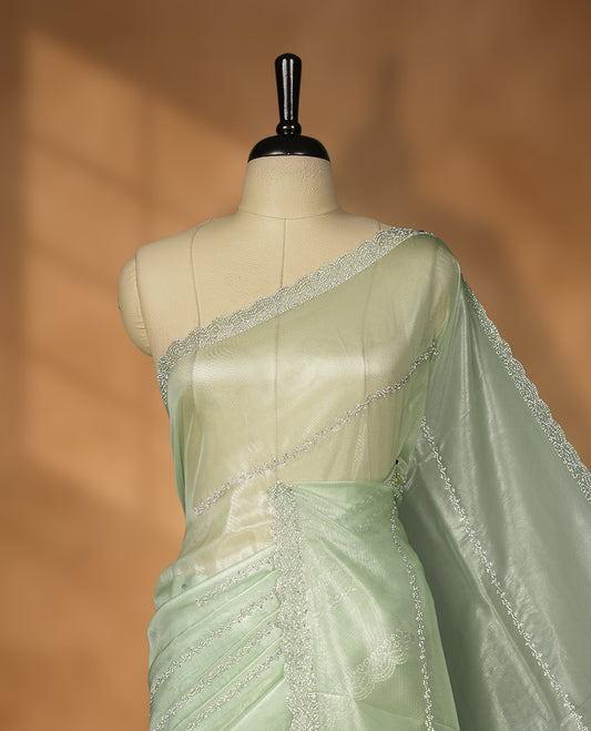 Mint Green Colour net shimmer fancy saree adorned with strip white stone buttas all over the body, paired with a delicate stone worked border and matching blouse