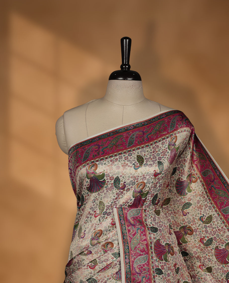 Ivory colour Pashmina silk saree richly woven with all over multicolour dancing figurines and paisley motifs, highlighted by a vibrant pink & green zari border and grand panelled pallu, paired with a matching woven border blouse piece.