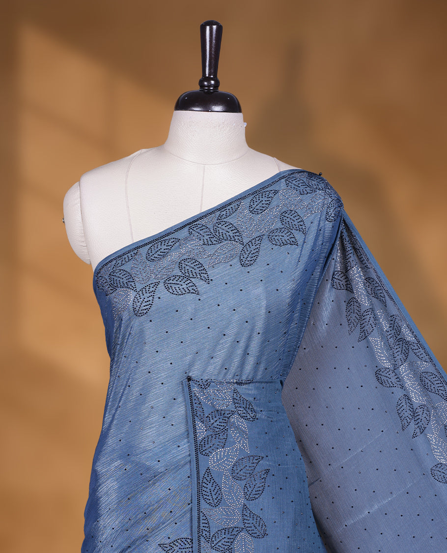 Ash blue colour chiffon designer saree, featuring black and white scattered stone on body, stone work and heavy stone leaf pattern on border and  pallu, Paired with matching blouse.