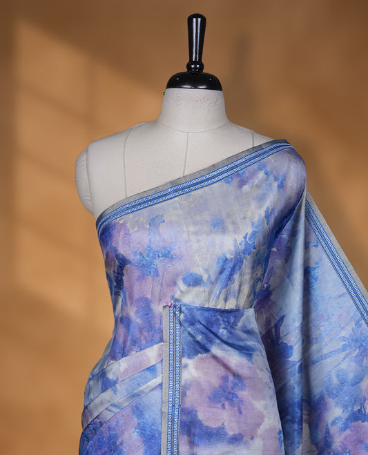 Royal blue colour semi tussar silk saree featuring an abstract digital floral printed body with a rich self border and tasselled pallu, paired with a matching blouse.