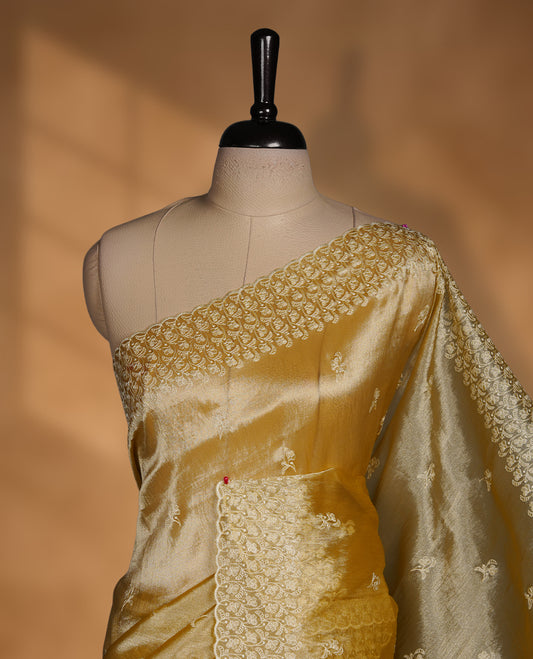 Pastel yellow colour organza saree featuring white thread embroidery motifs on body and  thread detailing on the border and paired matching blouse.