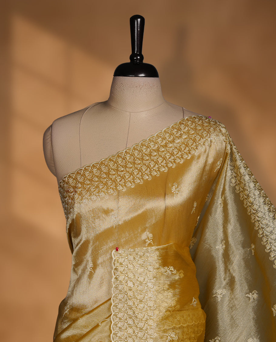 Pastel yellow colour organza saree featuring white thread embroidery motifs on body and  thread detailing on the border and paired matching blouse.