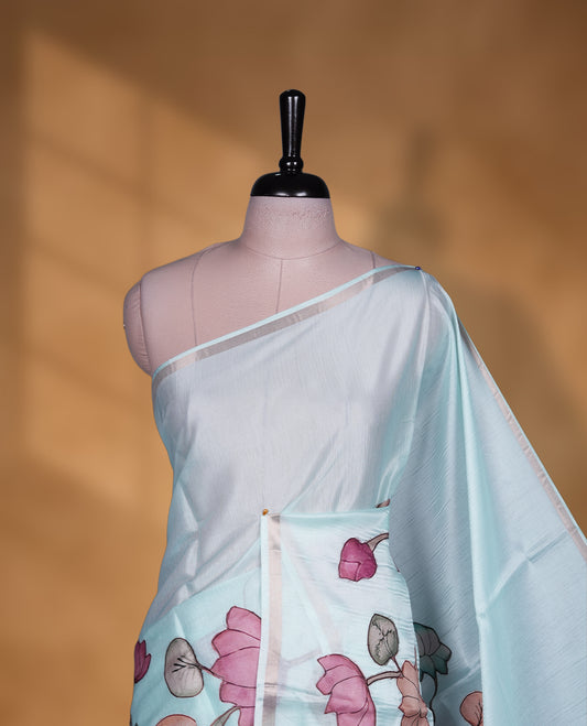 Light aqua blue colour semi tusser silk saree featuring delicate hand painted floral motifs along the pallu and border finished with subtle tassels and paired with a matching blouse.