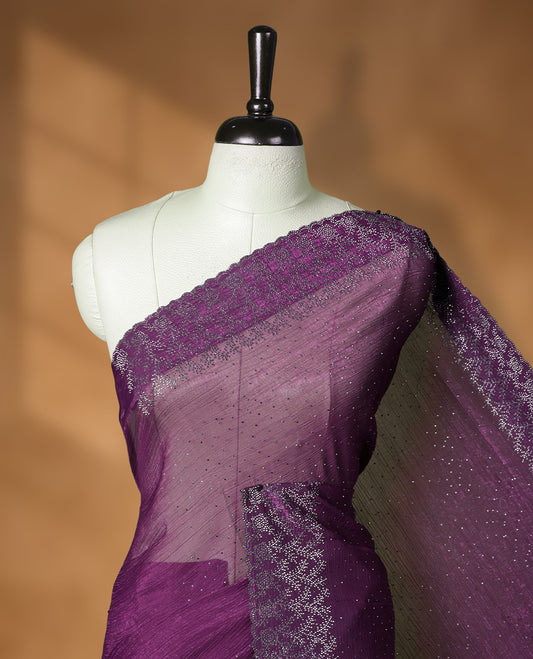 Dark purple colour chiffon designer saree, featuring white stone all over on body, heavy stone patttern on border and  pallu, Paired with matching blouse.