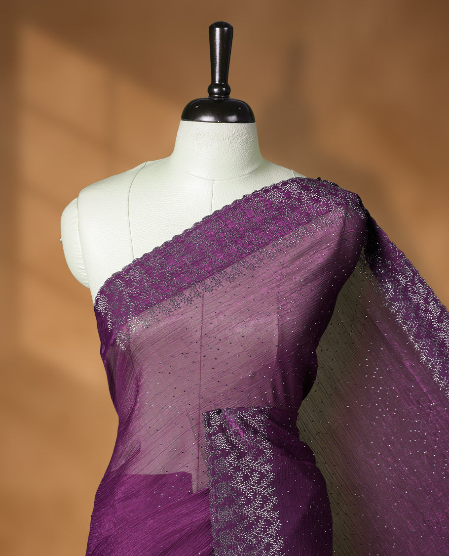 Dark purple colour chiffon designer saree, featuring white stone all over on body, heavy stone patttern on border and  pallu, Paired with matching blouse.