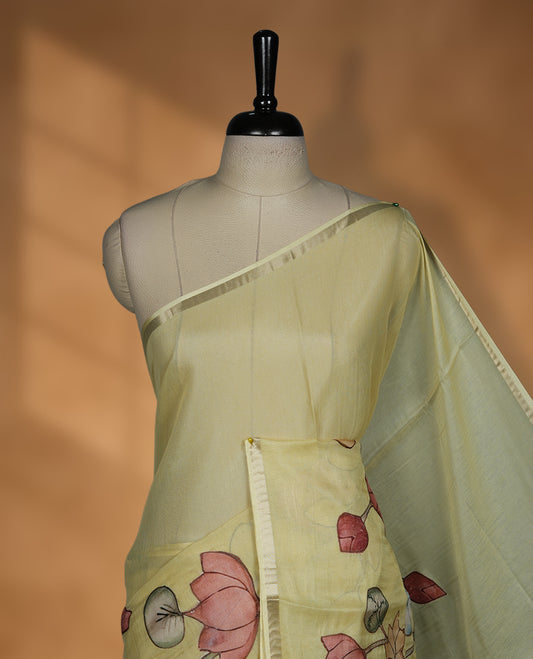 Pastel yellow colour semi tusser silk saree featuring delicate hand painted floral motifs along the pallu and border finished with subtle tassels and paired with a matching blouse.