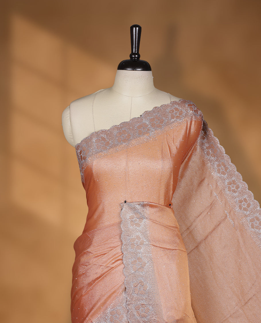 Peach colour shimmer designer saree, featuring a stone motifs on body, with  heavy stone patttern on border and  pallu, Paired with matching blouse.