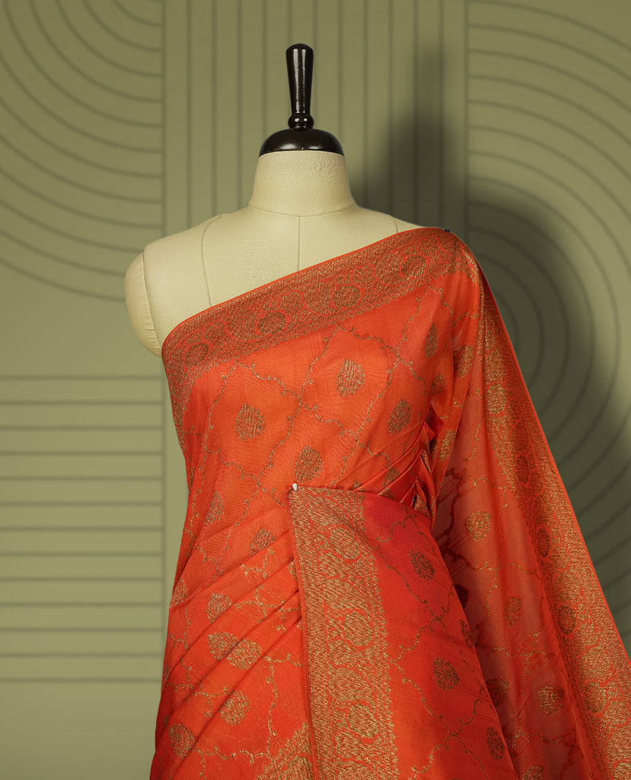 Orange colour semi Banarasi Tussar Georgette saree with gold zari motifs on the body, a grand woven golden pallu, and ornate zari border. Includes a matching blouse piece for a complete look.