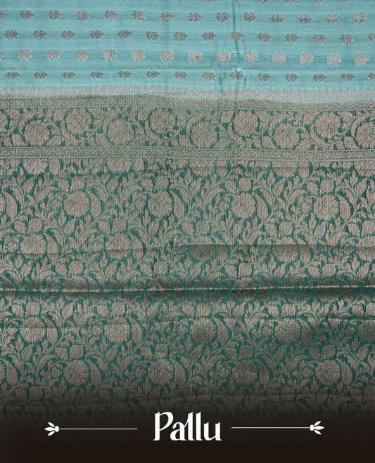 Sky blue colour Banaras silk saree featuring gold zari buttas on body, complemented by contrast teal colour border, comes with matching blouse piece.