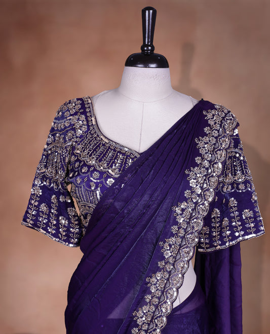Elegant deep purple colour ready to wear saree adorned with rich gold bead embroidery along the border and pallu, paired with a heavily embellished matching blouse for a grand festive look.