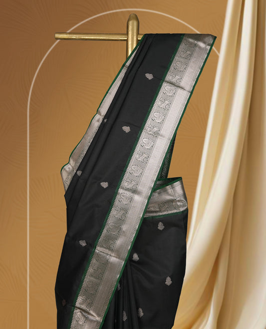 Black colour soft silk saree with green and copper zari border and featuring elegant copper buttas across the body & Paired with a amatching blouse.