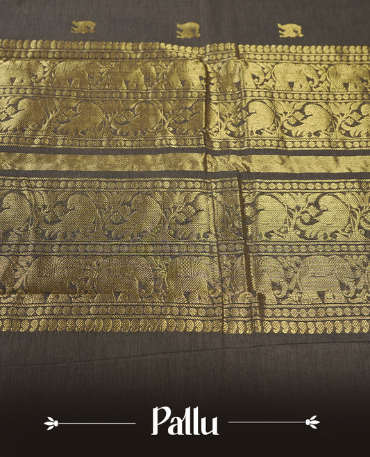 Grey colour Pure Kanchi cotton saree adorned with subtle golden buttas all over, highlighted by a rich zari woven border with traditional motifs  & Includes a matching blouse piece for a complete look.