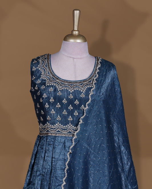 Midnight blue colour stitched gown set with sleeveless embroidered yoke, flared ankle‑length silhouette, and attached dupatta featuring dainty butti work and scalloped beaded edging.