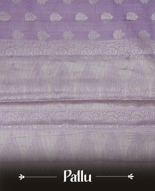 Lavender colour Banaras saree featuring Silver zari buttas on body, complemented by zari pattern on self colour border, comes with matching blouse piece.