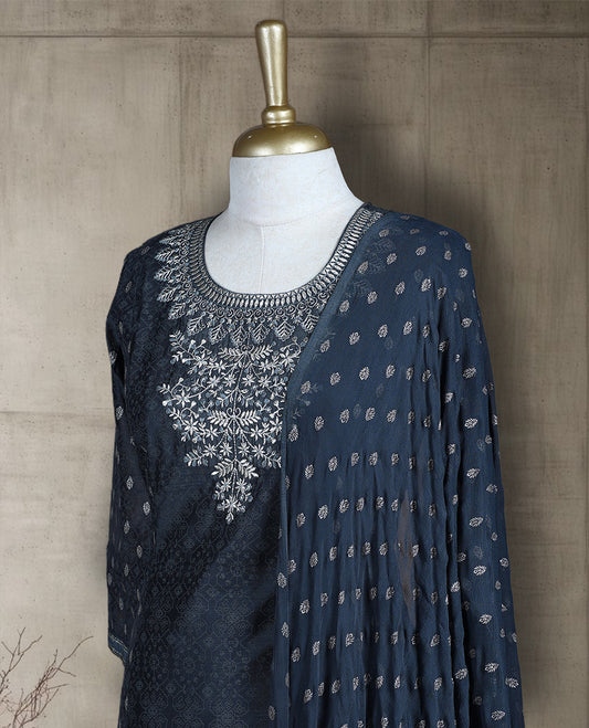 Dark grey colour salwar from TWARA, featuring a delicate silver embroidered neck with floral thread work, all over silver style embroidery on the top, paired with a matching bottom and an elegant dupatta.