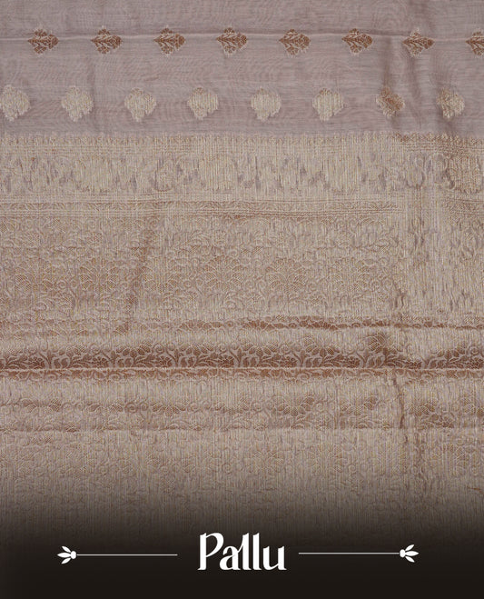 Beige colour Banaras silk saree featuring gold zari buttas on body, complemented by self colour with zari border, comes with matching blouse piece.