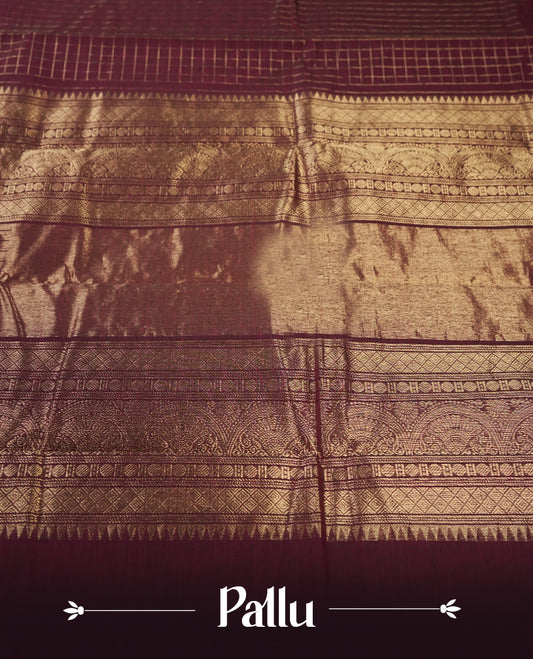 Maroon colour pure Kanchi cotton saree featuring with delicate golden checks on body, paired with a contrasting navy blue zari woven border & Includes a matching blouse piece for a complete look.