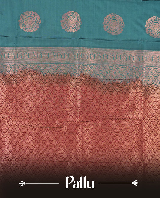 Teal colour Semi Silk Saree with gold zari motifs on the body, paired with a contrast Dark maroon colour pallu with gold zari traditioal border, and a matching blouse piece.
