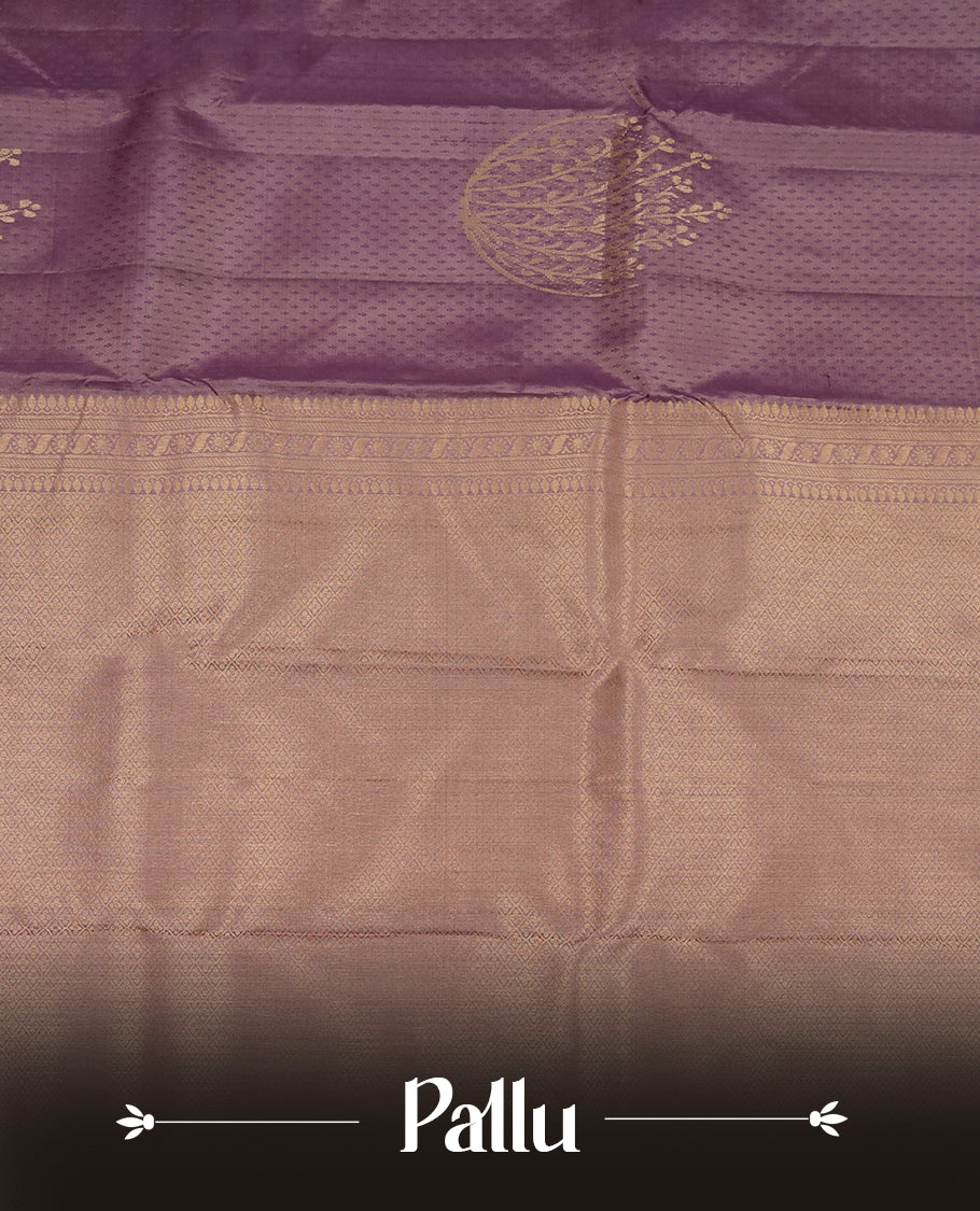 Dusty purple colour Vasundhara silk saree featuring self colour zari motifs across the body, finished with a self‑coloured traditional border with kathir motifs and a coordinating blouse.