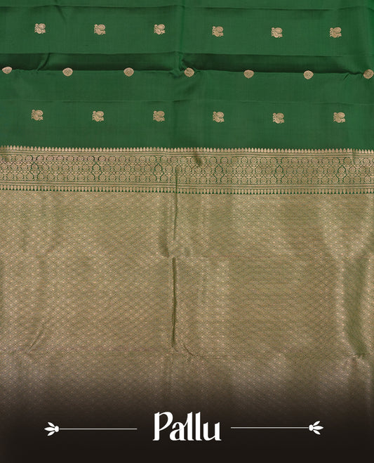 Dark Green colour Vasundhara silk saree adorned with all-over gold chakkaram & mayil motifs on the body, complemented by a gold tarditional border and paired with a matching blouse piece.