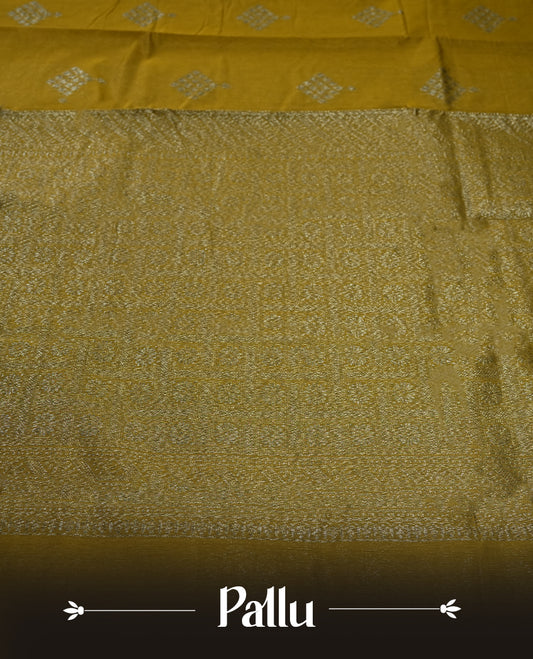 Bronze yellow colour silk cotton saree adorned with silver zari buttas and a rich zari border, complemented by a finely woven pallu & Paired with a matching blouse, perfect for festive gatherings and traditional occasions.