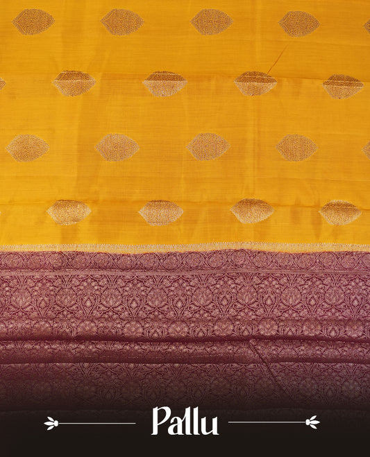 Golden Yellow Colour Banaras Soft Silk Saree with Gold Zari Oval Textured Buttas, Simple Decorative Pallu Border, Grand Pallu with Ornate Circular and Foliate Motifs in Maroon and Gold Tones, and Matching Deep Maroon Blouse.
