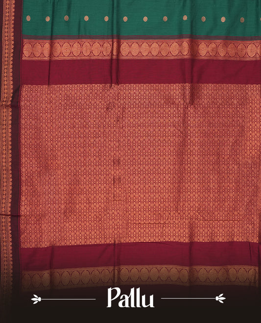 Teal green Kalyani cotton saree with contrast maroon border highlighted by rich golden zari weaving and elegant buttas on the body & Comes with blouse.