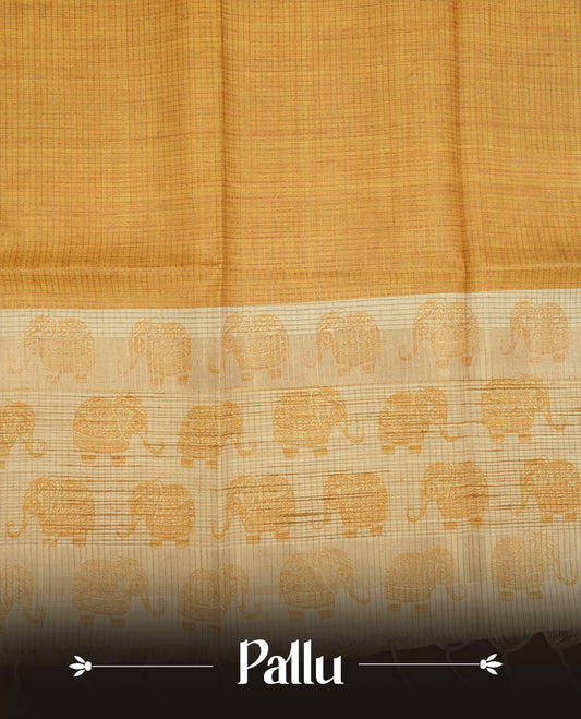 Golden yellow colour semi tussar silk saree featuring an all-over elephant motif print across the body, complemented by a contrasting pallu and border, and paired with a matching blouse piece.