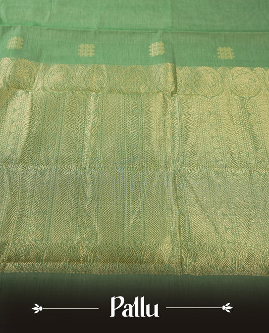Mint Green colour Pure Kanchi cotton saree featuring delicate golden buttas and a rich zari border with intricate motifs & Paired with a matching blouse, it exudes timeless elegance, perfect for festive and traditional occasions.